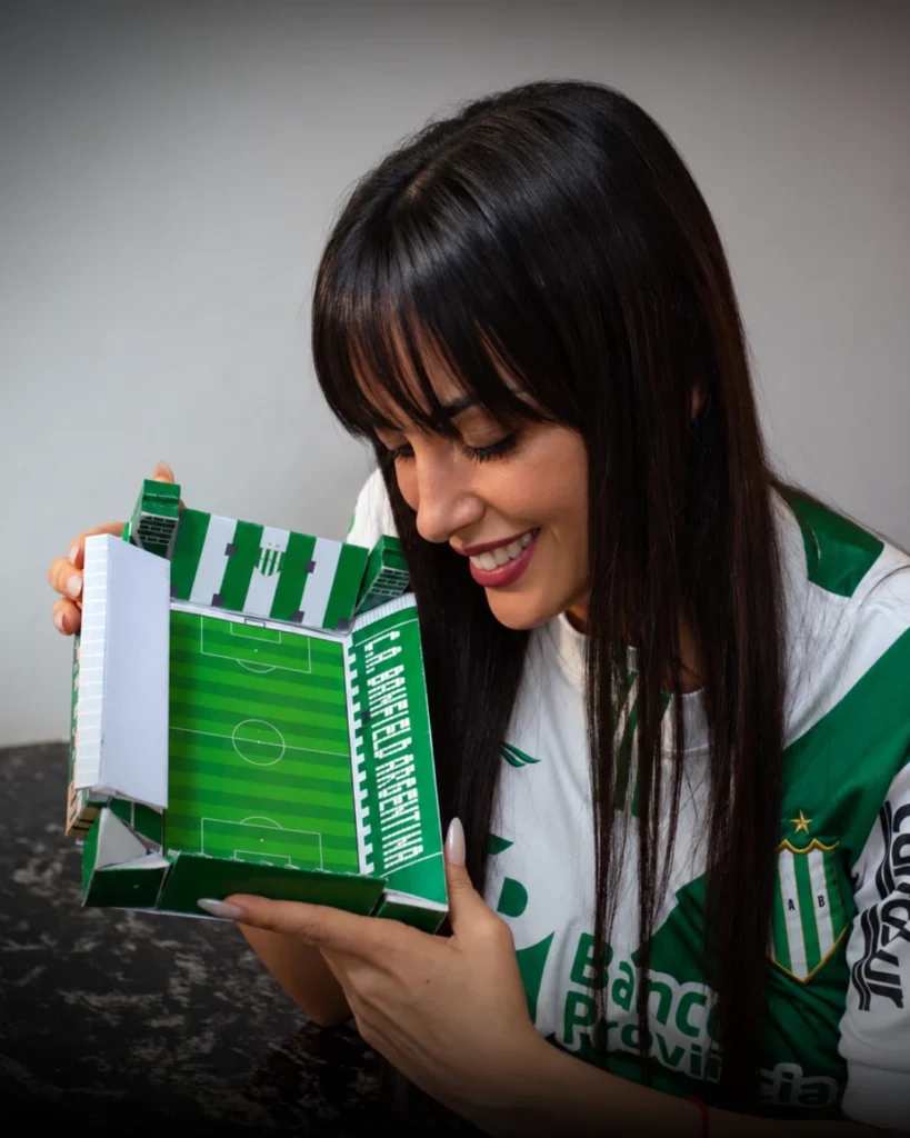 Gery sonriendo con el estadio Florencio Sola a escala terminado, con la camiseta de Banfield
